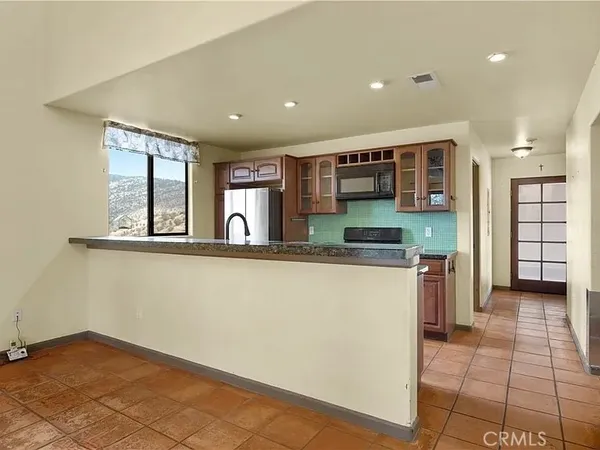 a kitchen with stainless steel appliances granite countertop a refrigerator and a stove top oven