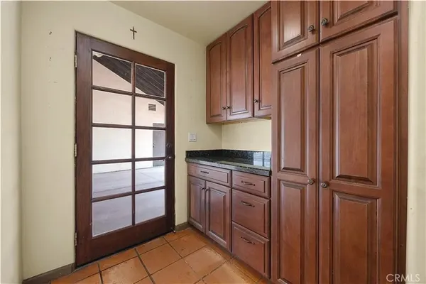 a kitchen with granite countertop a refrigerator and cabinets