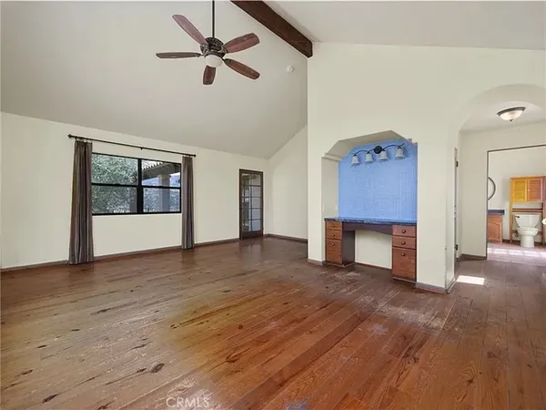 a view of a livingroom with wooden floor and a ceiling fan