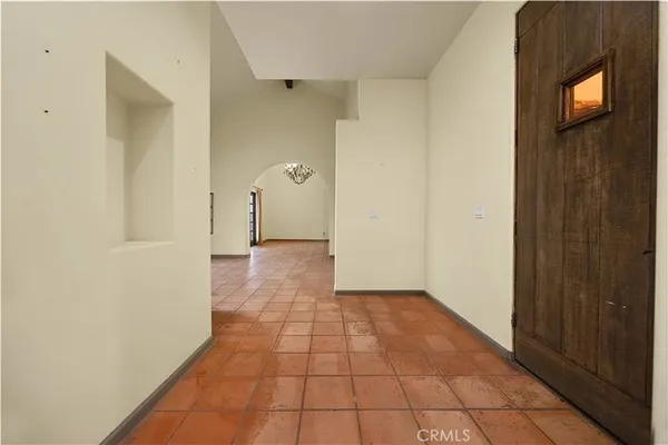 a view of a hallway with wooden floor and a bathroom