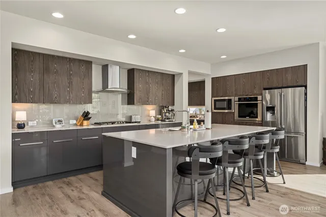 a kitchen with stainless steel appliances granite countertop a table chairs sink refrigerator and cabinets