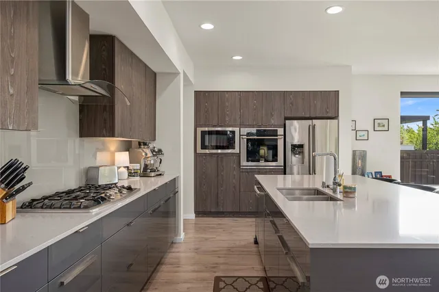 a kitchen with kitchen island stainless steel appliances a sink stove and refrigerator