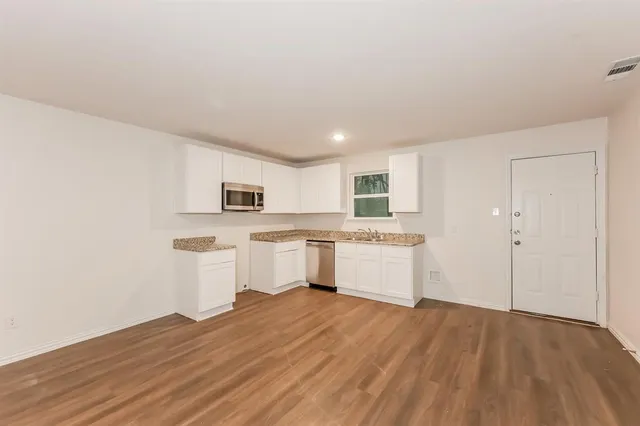 a kitchen with a sink cabinets and wooden floor