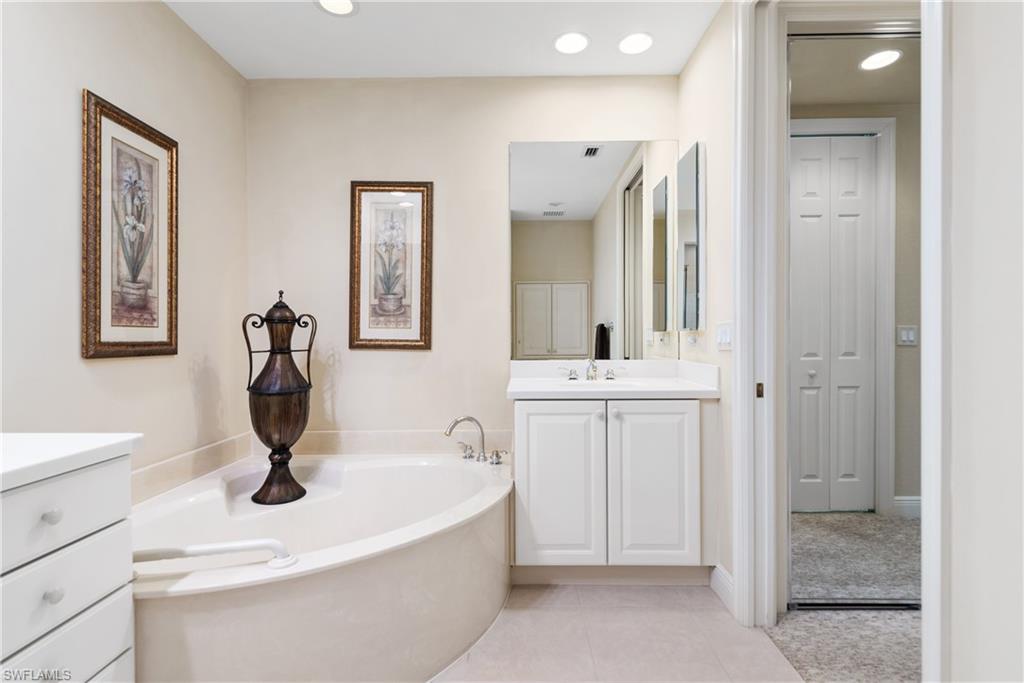 7837 Hawthorne Drive, Unit 1101 Naples, FL 34113 - Photo 14 of 26 a bathroom with a sink a toilet and a mirror