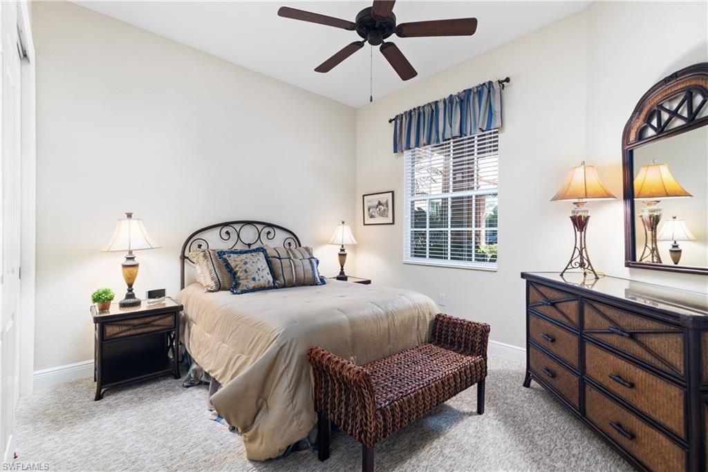 7837 Hawthorne Drive, Unit 1101 Naples, FL 34113 - Photo 15 of 26 a bedroom with a bed a dresser and windows