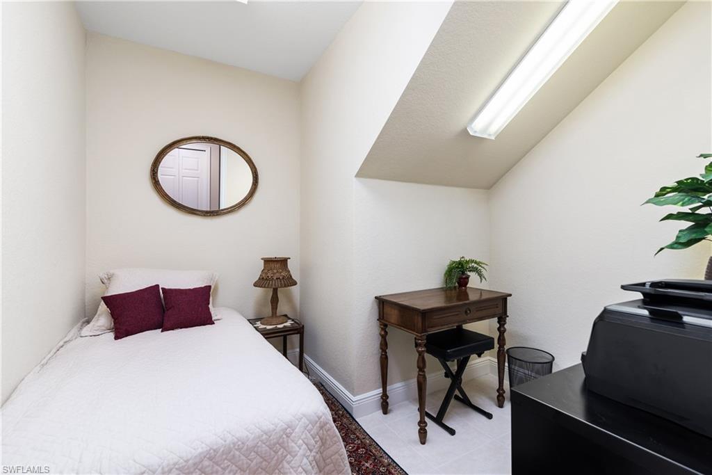 7837 Hawthorne Drive, Unit 1101 Naples, FL 34113 - Photo 17 of 26 a bedroom with a bed and a table