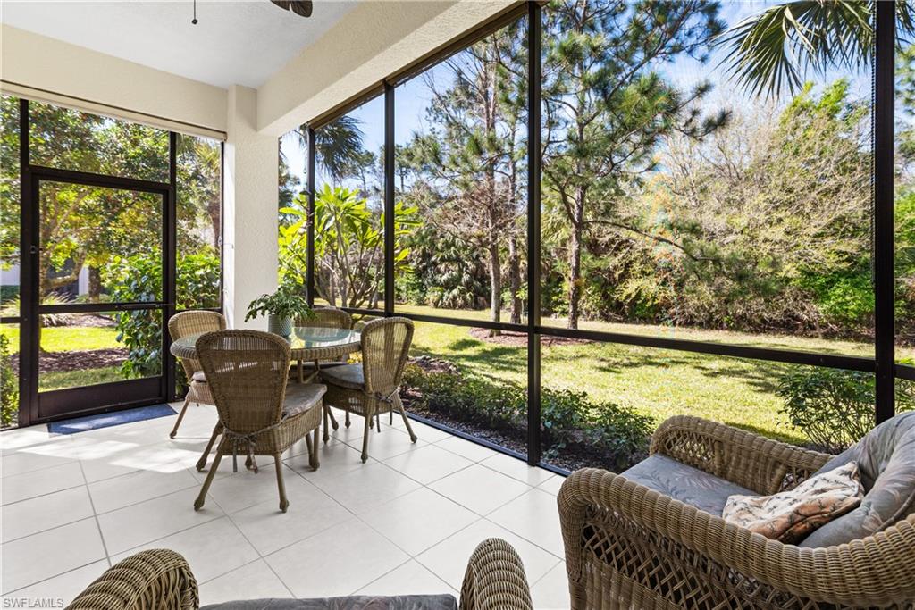 7837 Hawthorne Drive, Unit 1101 Naples, FL 34113 - Photo 19 of 26 a living room with furniture and a floor to ceiling window