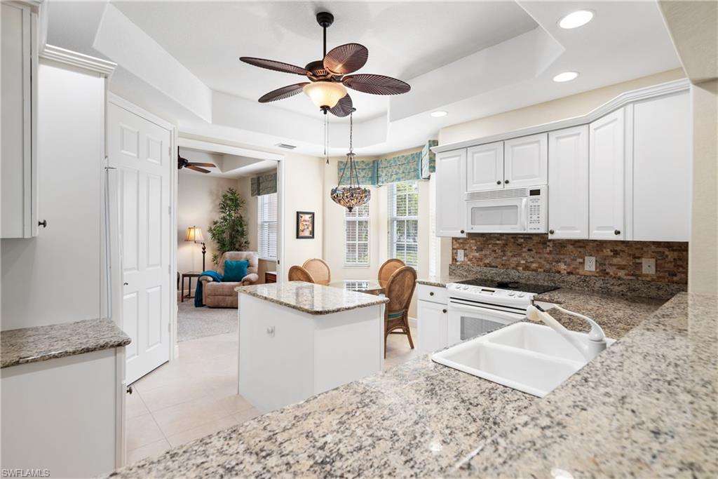 7837 Hawthorne Drive, Unit 1101 Naples, FL 34113 - Photo 6 of 26 a living room with furniture and a chandelier