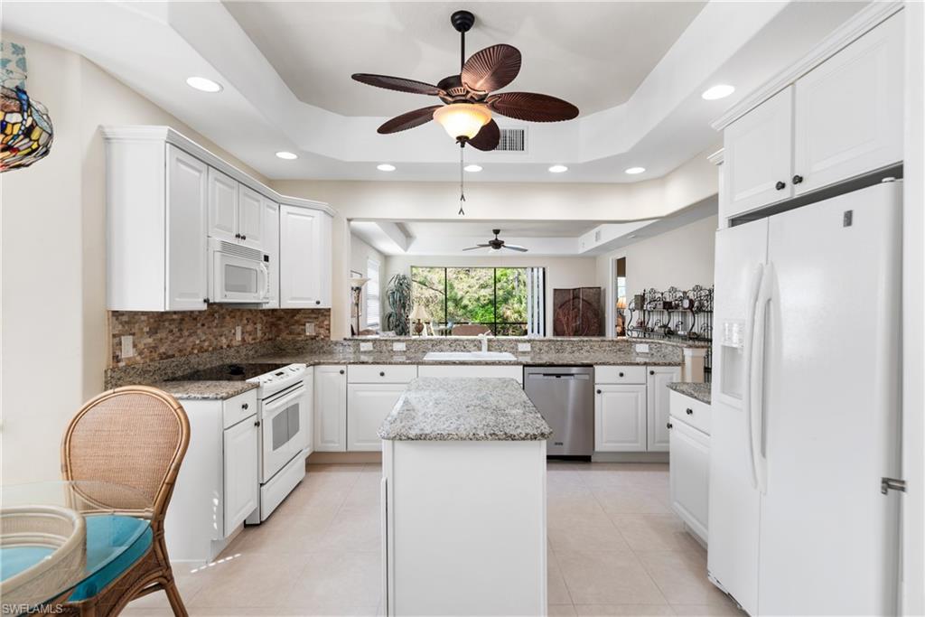 7837 Hawthorne Drive, Unit 1101 Naples, FL 34113 - Photo 8 of 26 a kitchen with stainless steel appliances granite countertop a stove oven a refrigerator a sink and white cabinets