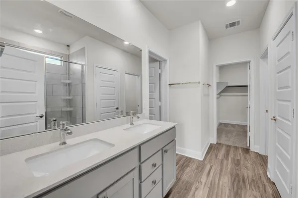 a bathroom with a double vanity sink a mirror and a shower
