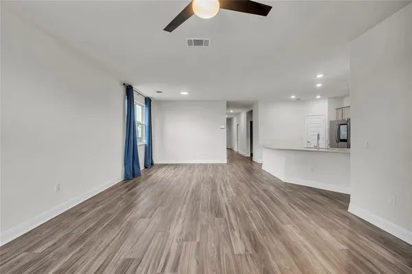 a view of an empty room with wooden floor