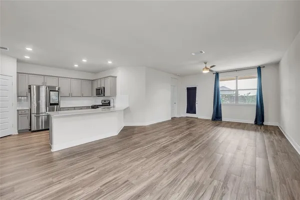 a view of kitchen with wooden floor and electronic appliances