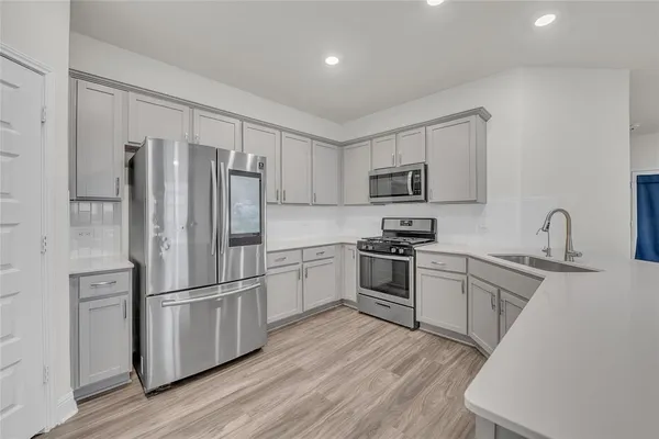 a kitchen with wooden cabinets and stainless steel appliances