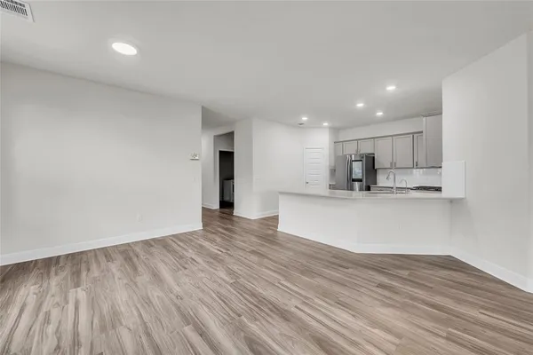 a view of kitchen with kitchen island wooden floor center island and stainless steel appliances