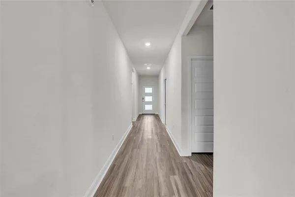 a view of a hallway with wooden floor