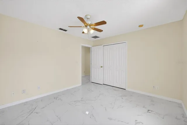 an empty room with a ceiling fan and a window