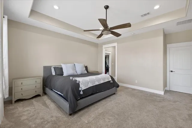 a spacious bedroom with a bed and a ceiling fan
