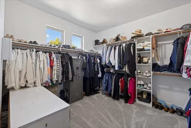 a view of walk in closet with clothes and shoes