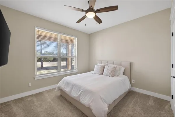 a bedroom with a large bed and a chandelier