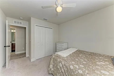 an empty room with closet and a ceiling fan