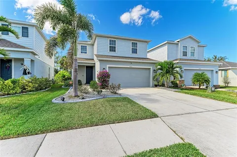 a front view of a house with a yard and potted plants