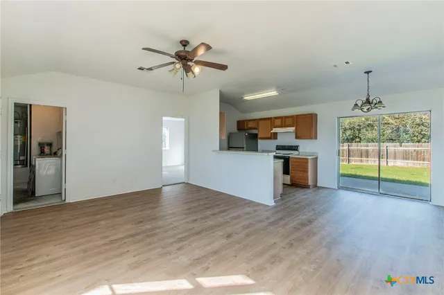 a view of empty room with wooden floor and fireplace