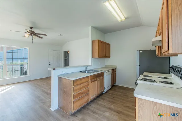 a kitchen with stainless steel appliances granite countertop a stove a refrigerator and a microwave