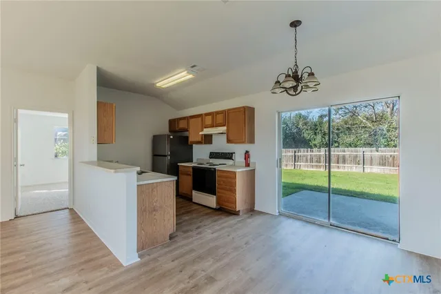 an empty room with ceiling fan and window