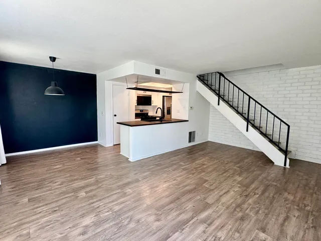 a view of a kitchen with wooden floor and electronic appliances