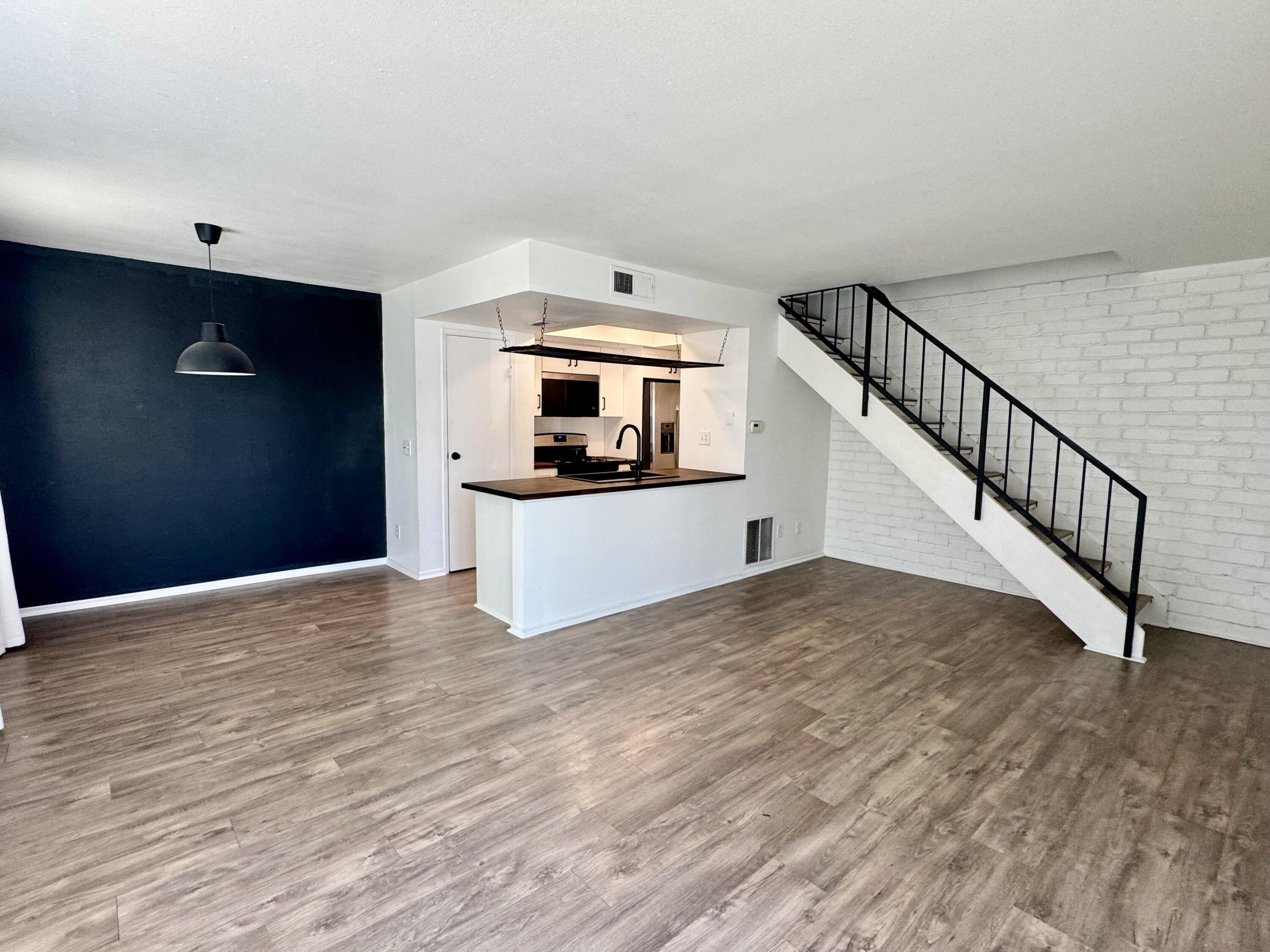 a view of a kitchen with wooden floor and electronic appliances