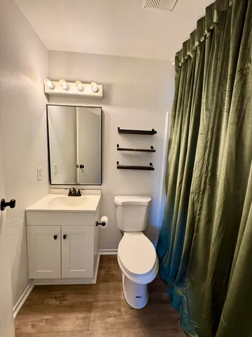a bathroom with a toilet a sink and a mirror