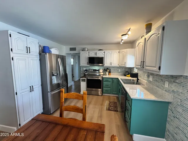 a kitchen with granite countertop stainless steel appliances a refrigerator sink and microwave