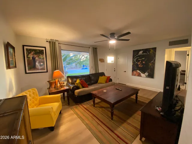 a living room with furniture a desk and chair with wooden floor