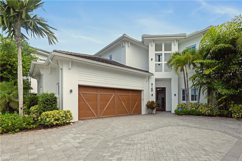 9169 Mercato Way Naples, FL 34108 - Photo 1 of 25 a front view of a house with a yard and garage