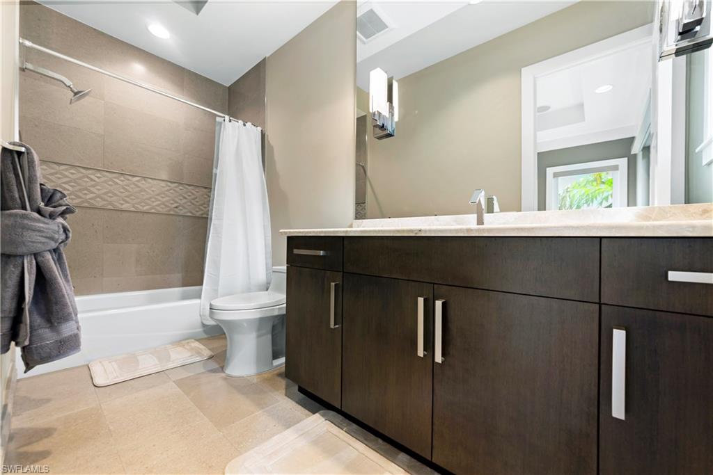 9169 Mercato Way Naples, FL 34108 - Photo 11 of 25 a bathroom with a sink and mirror with bathtub