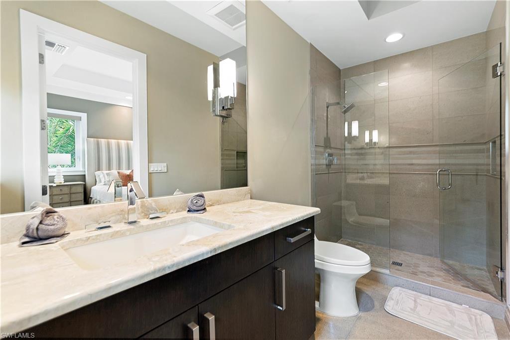 9169 Mercato Way Naples, FL 34108 - Photo 13 of 25 a bathroom with a sink a toilet a mirror and shower