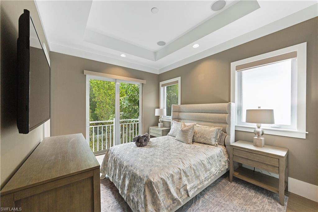 9169 Mercato Way Naples, FL 34108 - Photo 15 of 25 a bedroom with a bed and a flat tv screen next to a window