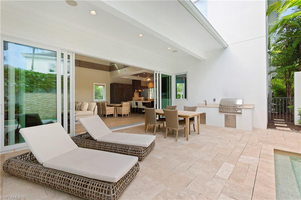 9169 Mercato Way Naples, FL 34108 - Photo 18 of 25 a living room with patio furniture and floor to ceiling window