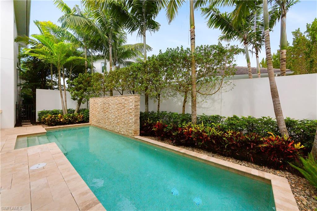 9169 Mercato Way Naples, FL 34108 - Photo 23 of 25 a view of a garden with a fountain and a large tree