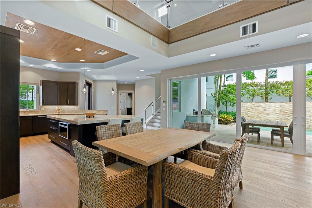 9169 Mercato Way Naples, FL 34108 - Photo 9 of 25 a view of a dining room with furniture and wooden floor
