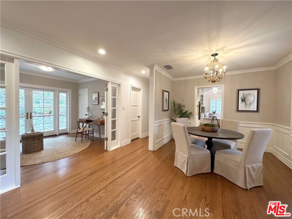 a living room with furniture a dining table and a large window