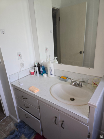1273 North 400 East, Unit 4 Logan, UT 84341 - Photo 7 of 12 Bathroom vanity featuring a white countertop with integrated sink, dual-handle faucet, and white cabinetry with drawer and cabinet storage