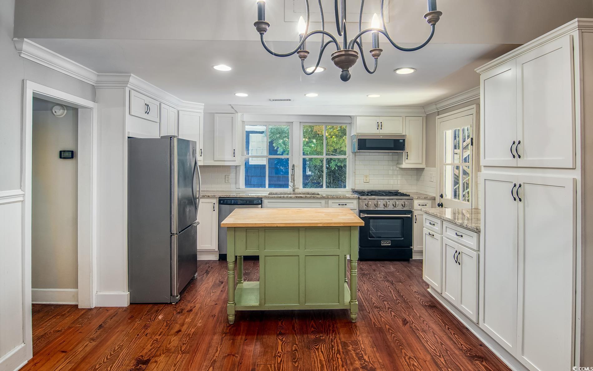 524 Highmarket Street Georgetown, SC 29440 - Photo 11 of 27 Kitchen featuring stainless steel appliances, white cabinets, backsplash, dark wood finished floors, and green cabinets