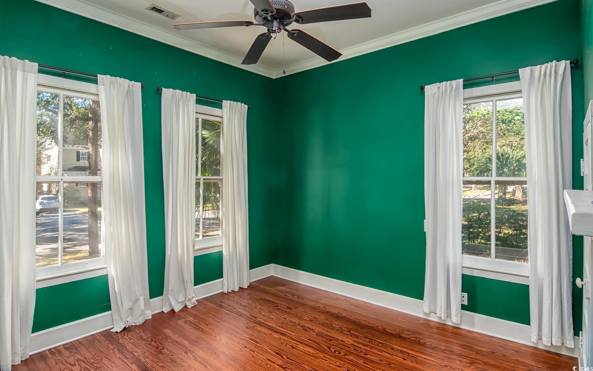 524 Highmarket Street Georgetown, SC 29440 - Photo 8 of 27 Empty room with wood finished floors, crown molding, and a ceiling fan