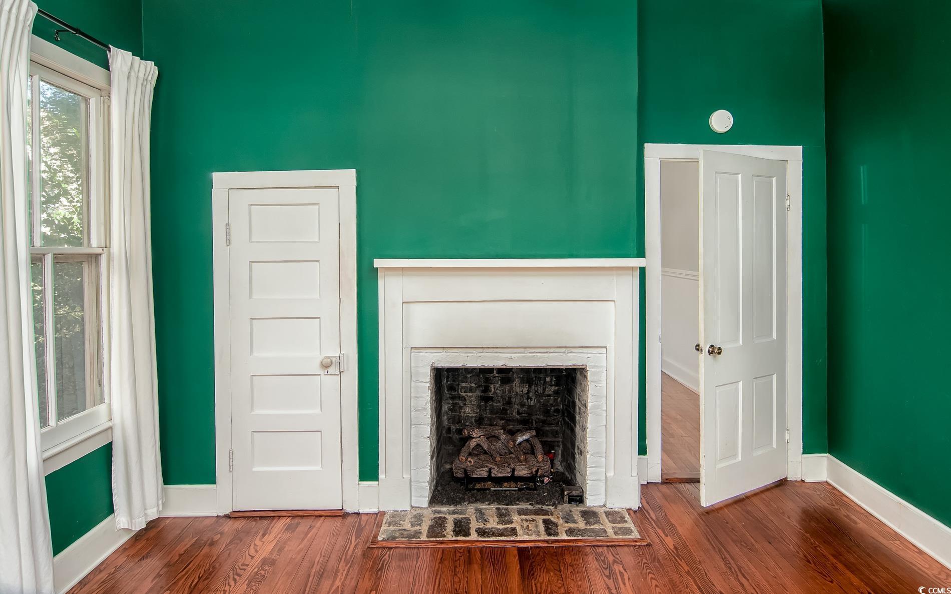 524 Highmarket Street Georgetown, SC 29440 - Photo 9 of 27 Unfurnished living room featuring a fireplace and dark wood-style floors