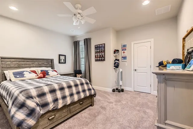 a spacious bedroom with a bed and a flat screen tv