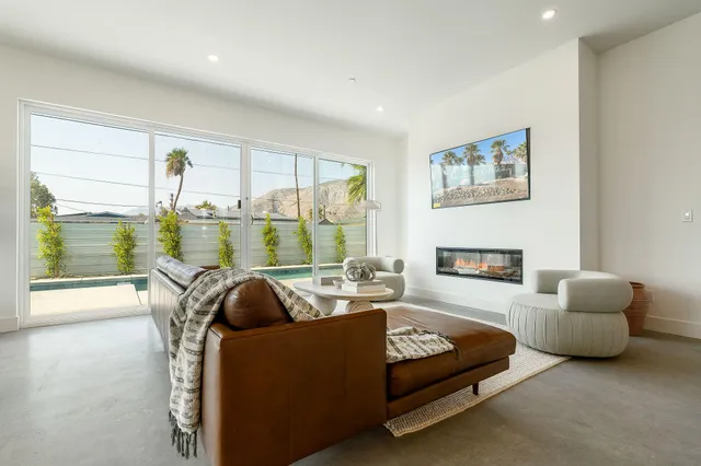 a living room with furniture and a floor to ceiling window
