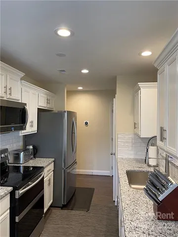 a kitchen with stainless steel appliances granite countertop a stove refrigerator and microwave