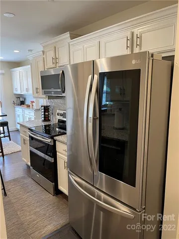 a kitchen with stainless steel appliances and refrigerator