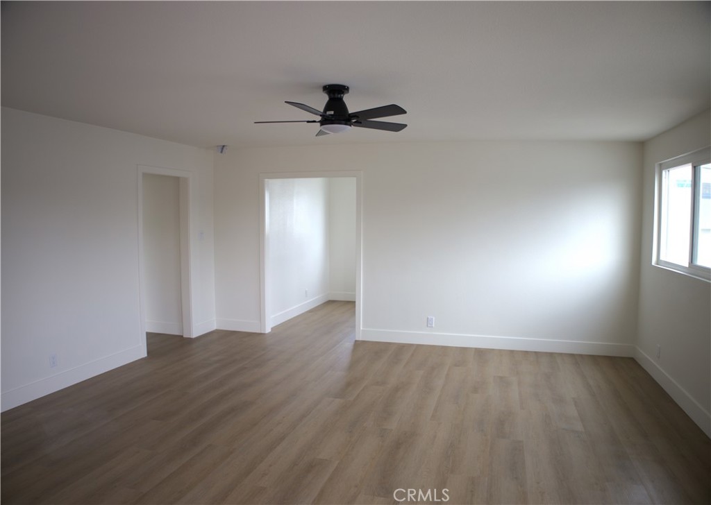 17420 Downey Avenue Bellflower, CA 90706 - Photo 8 of 11 an empty room with wooden floor cabinet and windows